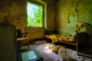 old abandoned children's home with a bed, chair, and an old stove