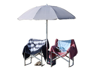 Beach umbrella providing shade to two empty chairs with towels
