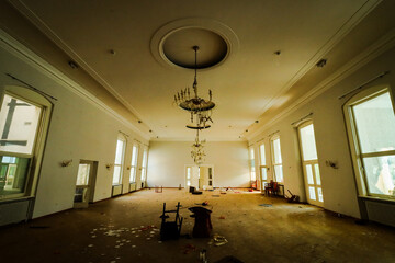hallway of an old hotel with chandeliers and chairs