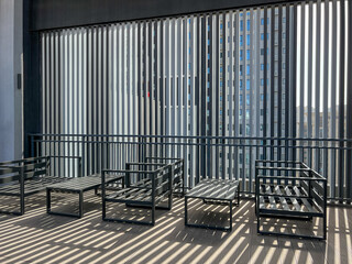 Modern outdoor seating area with metal furniture and vertical blinds