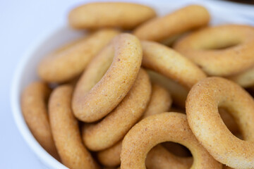 Freshly baked mini bagels on a dark background. Top view. Pretzels in the form of a ring close-up. Small bread circle biscuit. Bowls with different types of bagels.
