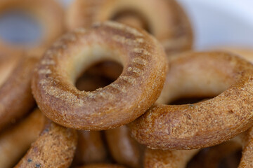 Freshly baked mini bagels on a dark background. Top view. Pretzels in the form of a ring close-up. Small bread circle biscuit. Bowls with different types of bagels.
