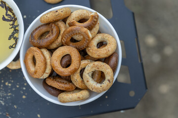Freshly baked mini bagels on a dark background. Top view. Pretzels in the form of a ring close-up. Small bread circle biscuit. Bowls with different types of bagels.
