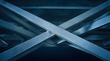 Naklejka premium Industrial metal beams forming an abstract geometric composition in a construction setting with cool steel tones.