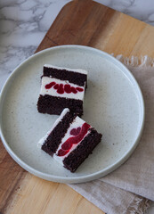 top view of  elegant dessert plate with cholate sponge, souffle and raspberry layer cake slice