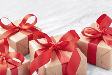 Gift boxes, present with red bow ribbon on marble table background, closeup