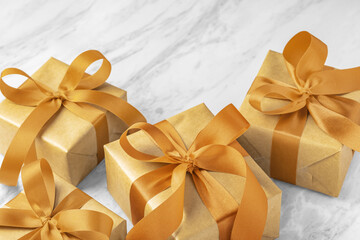 Christmas gift boxes, present with golden bow ribbon on marble table background