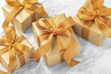 Gift boxes, present with gold bow ribbon on marble table