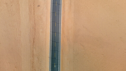 Aerial View of a Straight Road Cutting Through a Desert Landscape