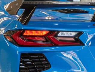 LED taillights of a modern sport car in close-up. Taillight or rear light of modern sport car in showroom. Close-up view of blue sport car rear light. Stylish modern sport car stop signal close up.