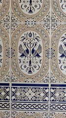 Ornate ceramic tiles with symmetrical blue and beige bird motifs and intricate floral patterns
