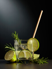 Cold refreshing drink with ice, lime, and rosemary.