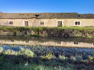 Old warehouses reflected in the Canal de Castilla in the city of Alar del Rey.