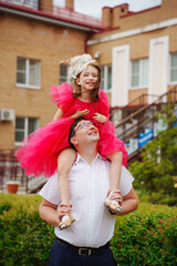 Happy well-dressed family on a walk. Dad and little daughter 