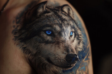 Realistic wolf tattoo with glowing blue eyes suitable for back, chest, shoulder and upper arm