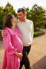 Man gently hugging pregnant woman while sitting in garden at home. 