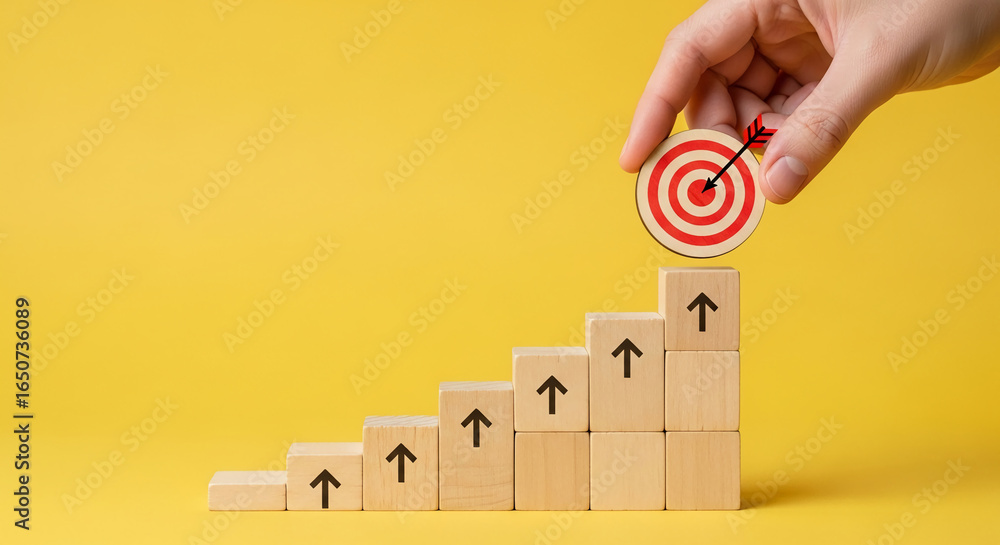 Poster wooden blocks form ascending stairs, topped by a target with an arrow, symbolizing achievement and p