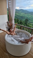 Handsome Man Unwinding in Bubble Bath with Stunning Mountain View at Twilight