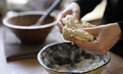 Kneading dough by hand on kitchen counter.