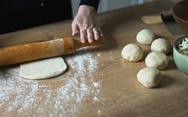 Rolling dough with wooden rolling pin kitchen.