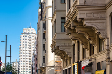 Neoclassical buildings on Madrid's Gran Via with Plaza de Spain in the background.