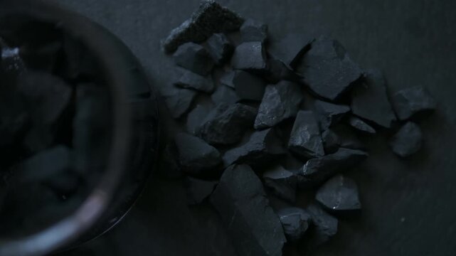 dark background top view,  shungite stones on a black background used in alternative medicine for water purification and recharge due to high carbon content and metaphysical properties cinematic