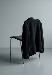 A dark textured jacket draped over a minimalist modern chair
