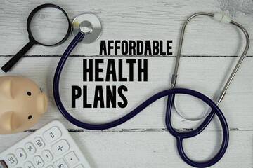 Affordable Health Plans text with Stethoscope and magnifying glass on wooden background