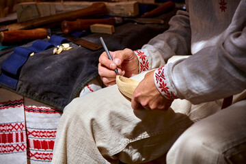 A Craftsman's Delicate Touch: Carving a Wooden Bowl in the Warm Light of a Workshop