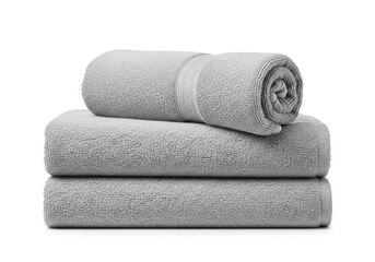 Stack of three soft grey bath towels rolled and folded neatly