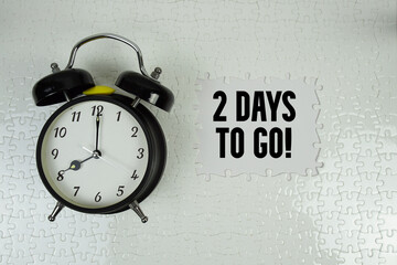2 Days To Go! with alarm clock on white background