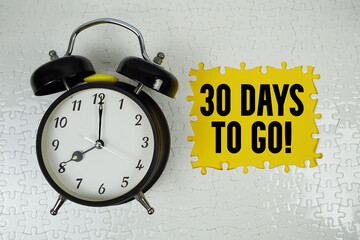 30 Days To Go! text with alarm clock on yellow background