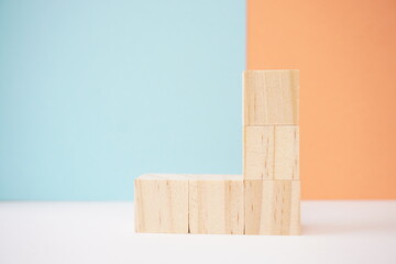 Wooden blocks set against a dual-color pastel background ideal for business, education, or instructional concepts