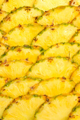 Pineapple juicy yellow slices background. Top view.