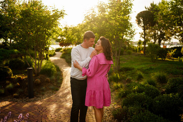 Man gently hugging pregnant woman while sitting in garden at home. 