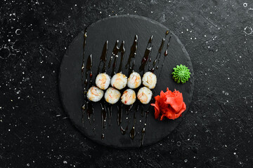 Classic sushi rolls with fish. Japanese food. On a black stone background. Top view. © Yaruniv-Studio