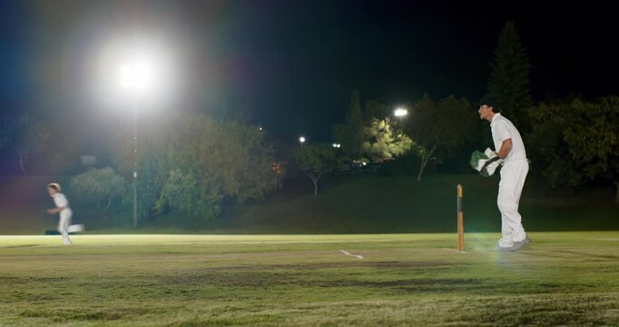 Bowler bowling on floodlit field, Indian batsman sprinting as keeper appealing and celebrating run
