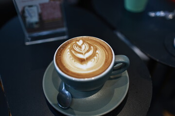 A vintage café scene with a steaming espresso in a white mug on a wooden table, rich with aroma,...
