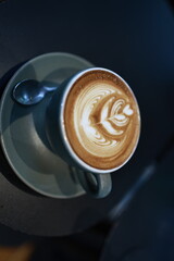 A vintage café scene with a steaming espresso in a white mug on a wooden table, rich with aroma,...