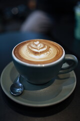 A vintage café scene with a steaming espresso in a white mug on a wooden table, rich with aroma,...