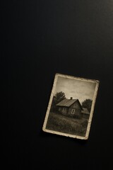 Faded vintage photograph of a rustic house on a black background