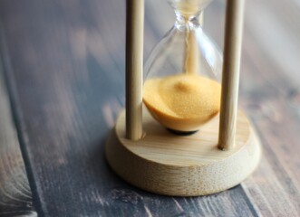 Hourglass in wooden table close up photo time 