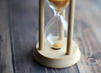 Hourglass in wooden table close up photo time 