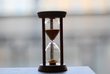 Hourglass on the windowsill in the evening time passes photo	
