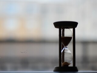 Hourglass on the windowsill in the evening time passes photo	
