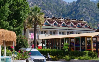 A daytime shot of a resort building features lush tropical vegetation and picturesque mountains in...