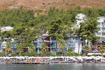 Coastal resort with beach, trees, and white buildings in Icmeler - Marmaris - Mugla - Turkey