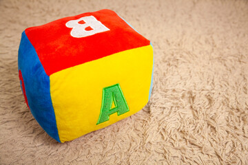 Children's plush dice with the letter A written on them. Letter concept.