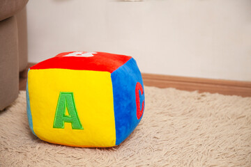 Children's plush dice with the letter A written on them. Letter concept.