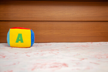 Children's plush dice with the letter A written on them. Letter concept.